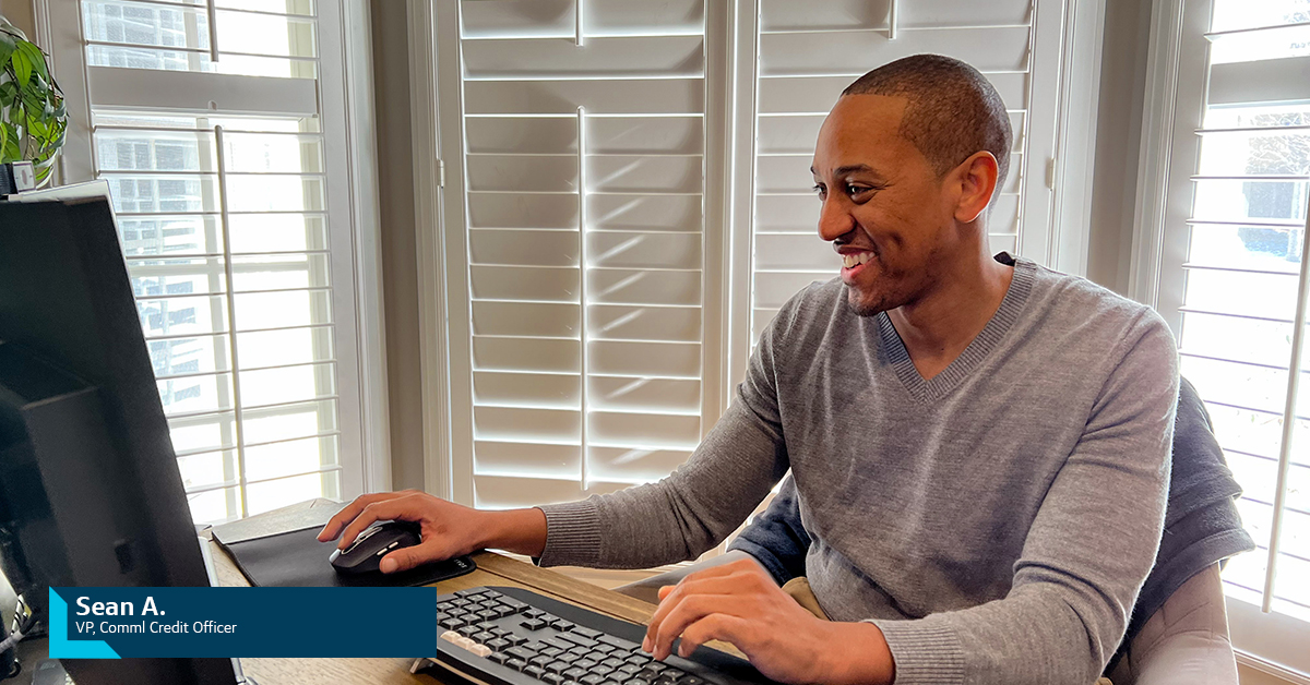 Sean A., Capital One VP of Commercial Credit Officer, sits and smiles in his home office at his computer